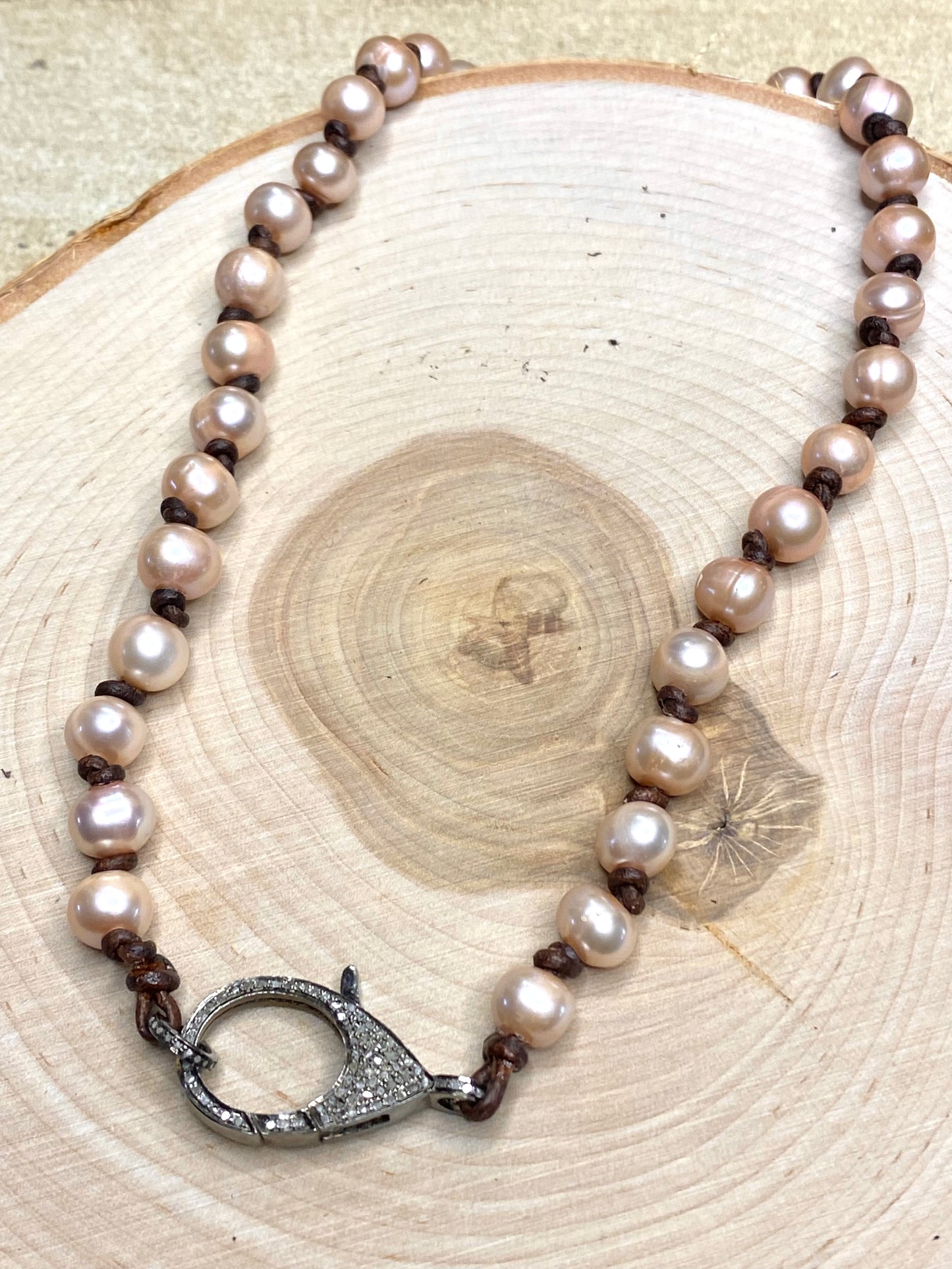 Pave diamond clasp and pink pearl necklace on leather