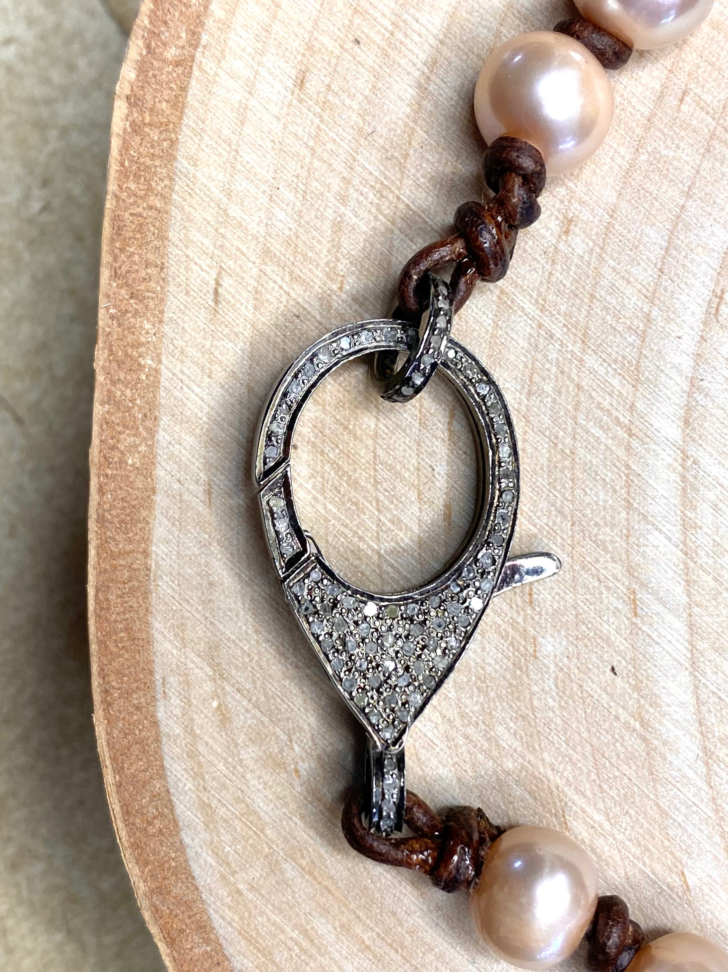 Pave diamond clasp and pink pearl necklace on leather