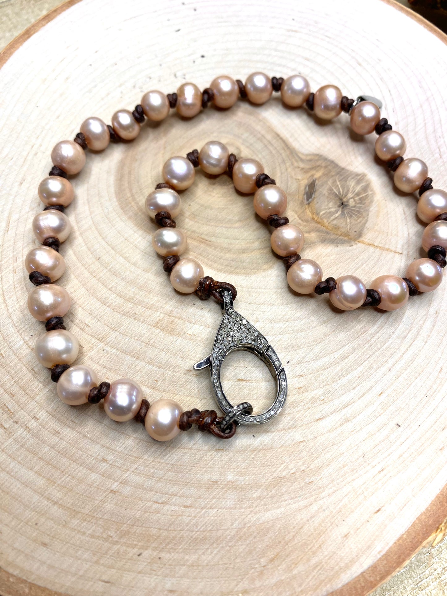Pave diamond clasp and pink pearl necklace on leather