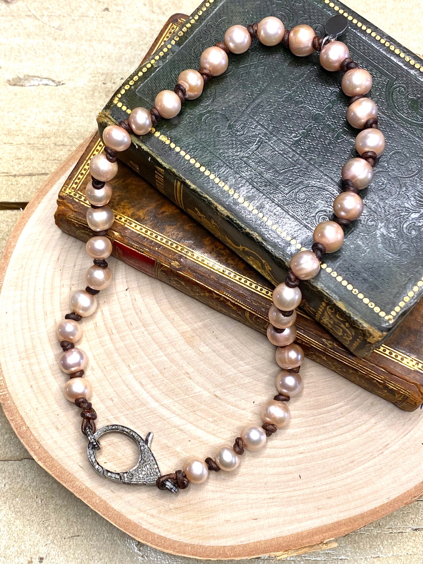 Pave diamond clasp and pink pearl necklace on leather