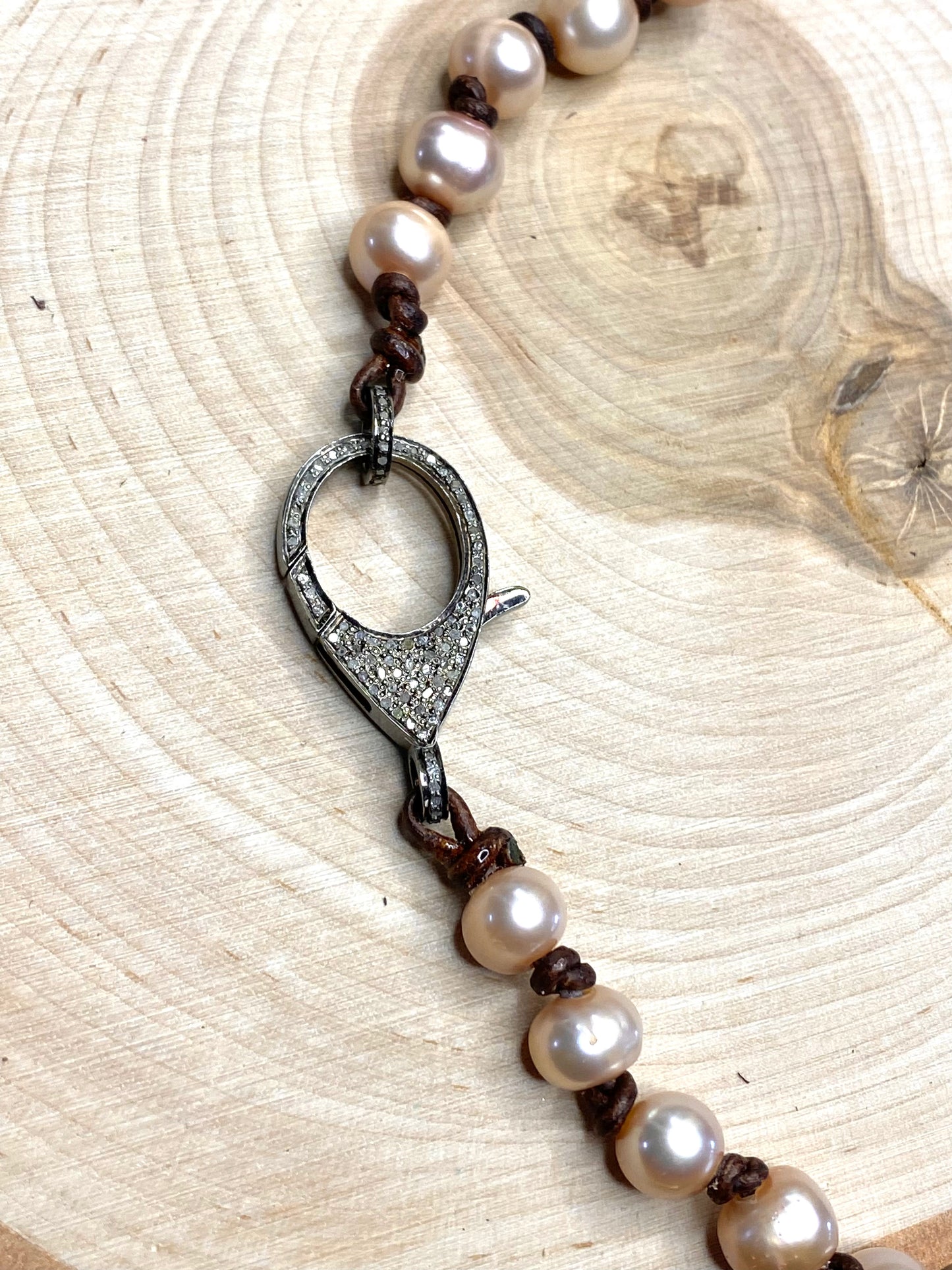 Pave diamond clasp and pink pearl necklace on leather